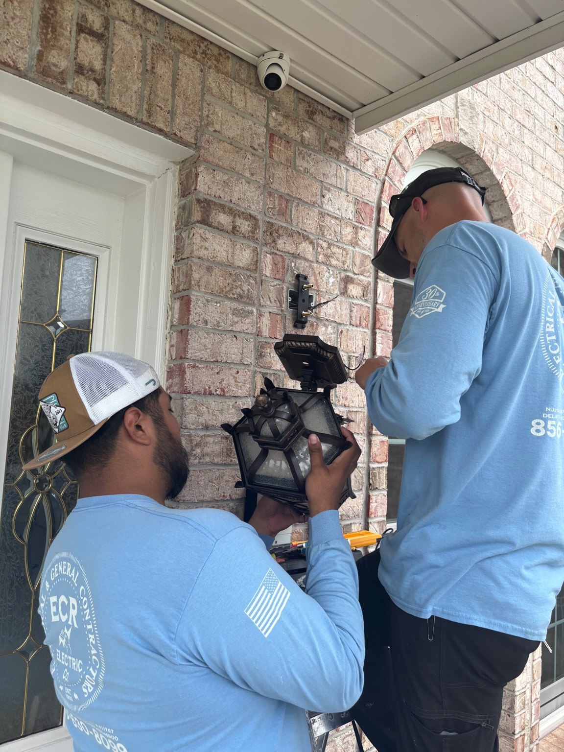 ECR electricians installing an exterior lantern